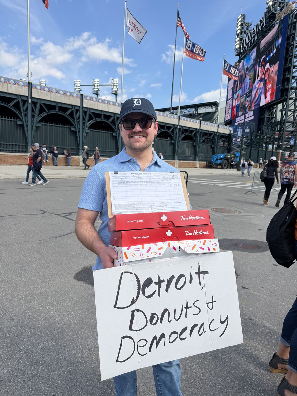 A Victory Field Operations team member out on a field program in Detroit with a clipboard of petition sheets.